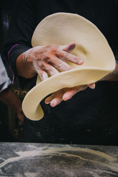 Ο Τεχνίτης μπουγάτσας την ώρα που ανοίγει το φύλλο στο χέρι. The mpougatsa expert technician at the time that produces the handmade fillo.